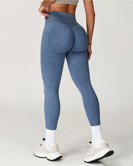 Person wearing blue leggings on a plain background
