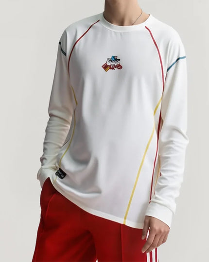 White long-sleeve athletic shirt with colorful accents and red shorts on a plain background
