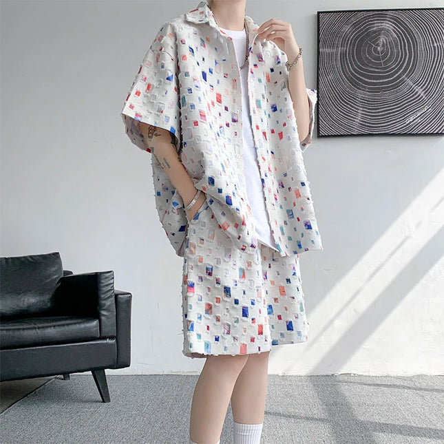 Person wearing a patterned outfit in a room with a black sofa and abstract wall art.