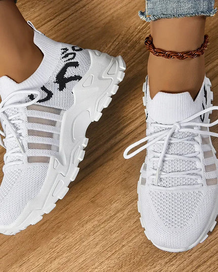 White sneakers worn on a wooden floor