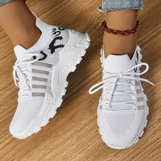 White sneakers worn on a wooden floor