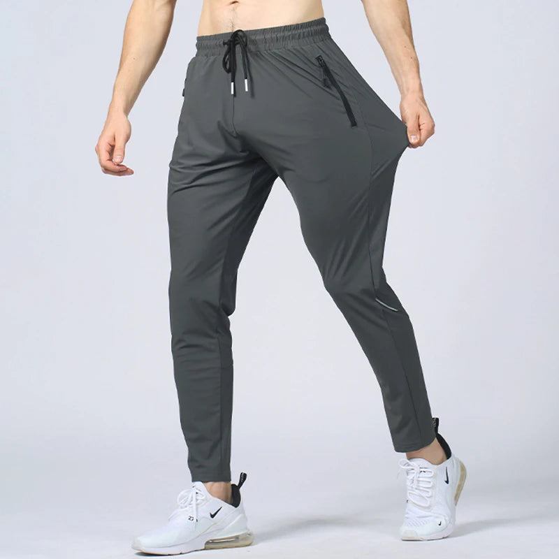 Gray athletic pants worn by a person on a light gray background