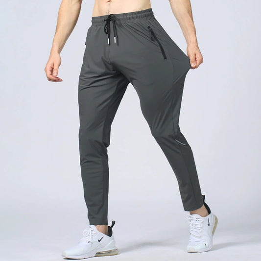 Gray athletic pants worn by a person on a light gray background