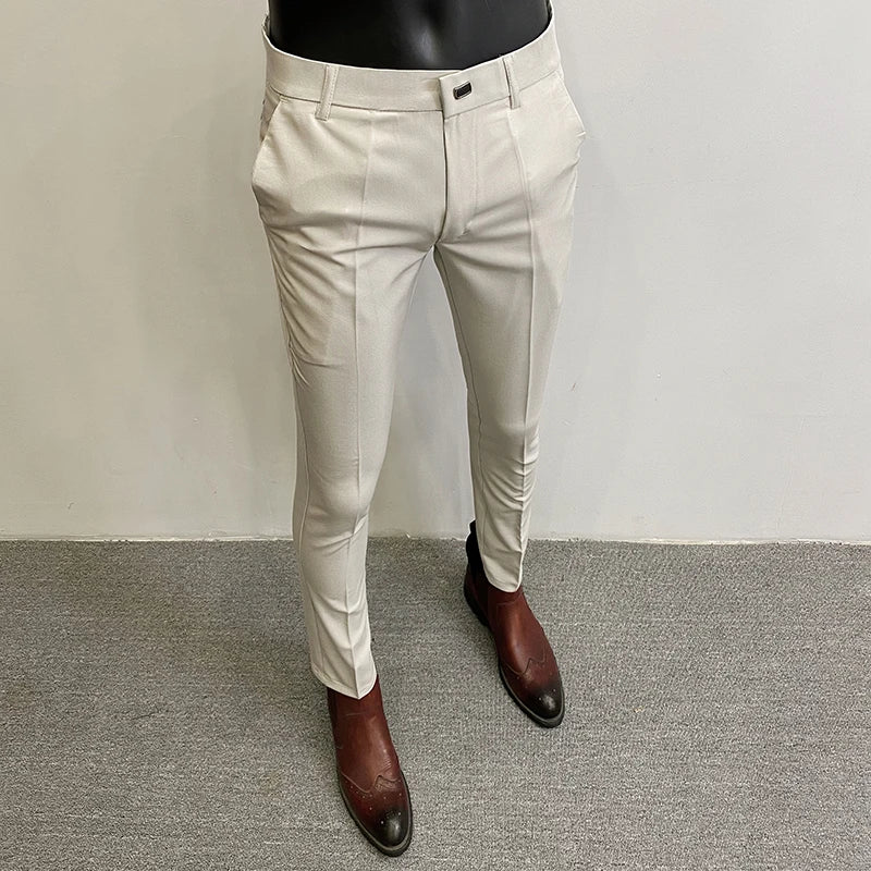 Beige pants worn by a mannequin on a gray floor with a white wall background