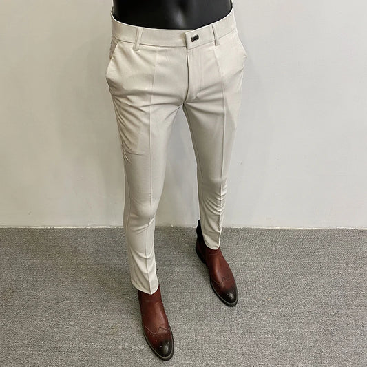 Beige pants worn by a mannequin on a gray floor with a white wall background