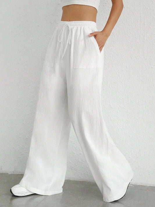 White wide-leg pants worn by a person on a plain background