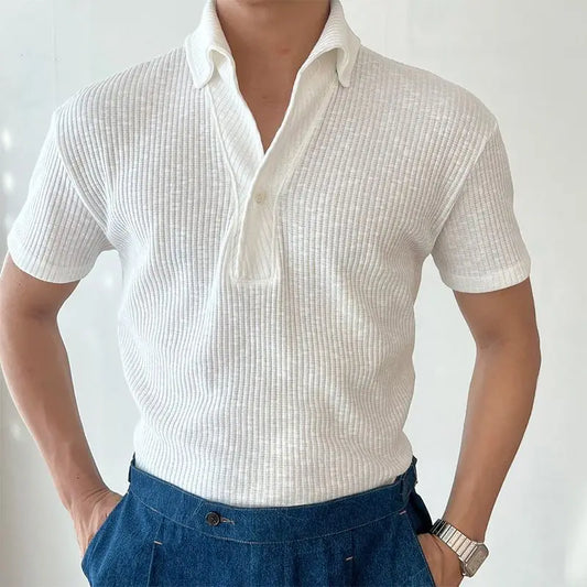 Person wearing a white textured short-sleeve shirt and blue pants against a light background