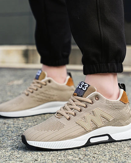 Beige sneakers with white soles worn on a concrete surface
