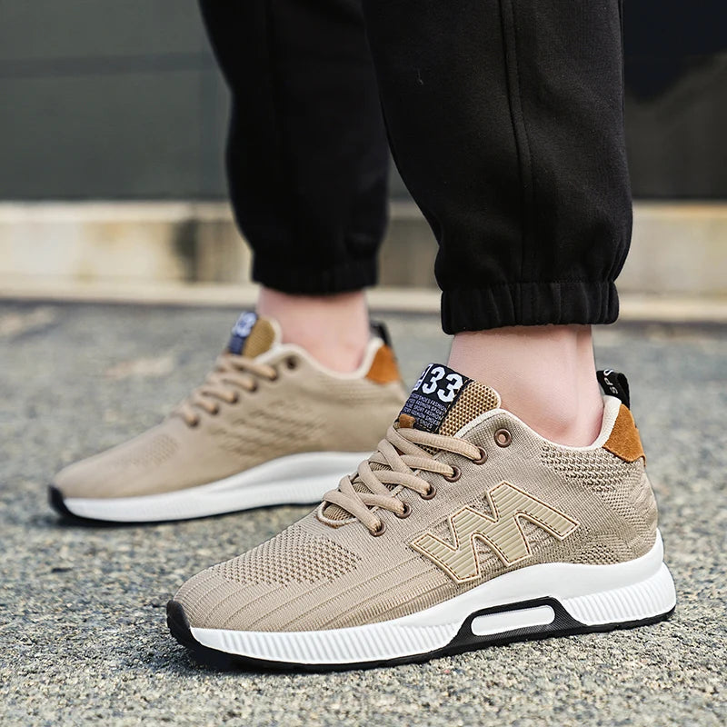 Beige sneakers with white soles worn on a concrete surface