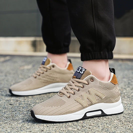 Beige sneakers with white soles worn on a concrete surface
