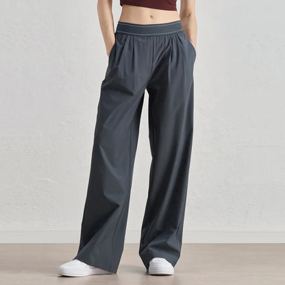 Person wearing gray wide-leg pants on a plain background