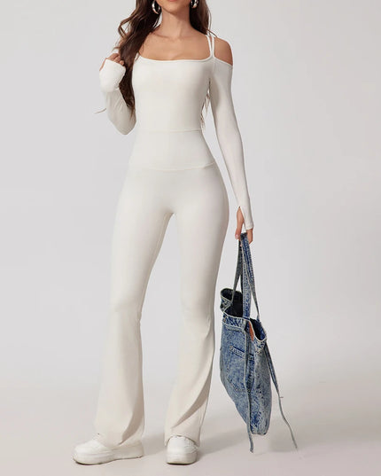 Person wearing a white outfit holding a denim bag on a plain background