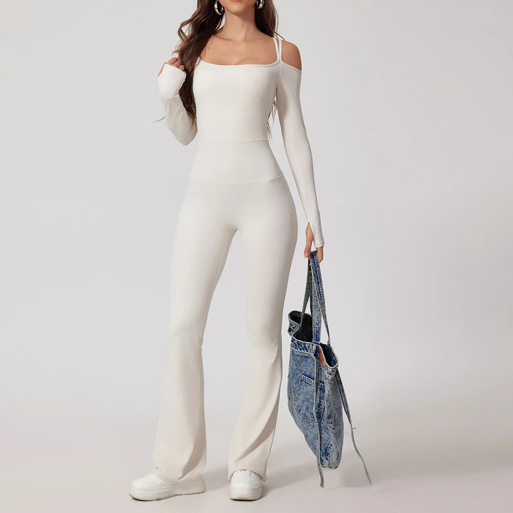Person wearing a white outfit holding a denim bag on a plain background