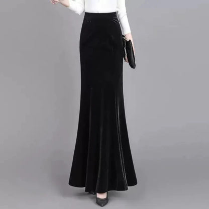Black velvet skirt worn by a person on a gray background