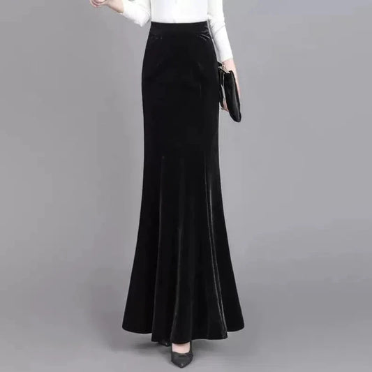 Black velvet skirt worn by a person on a gray background