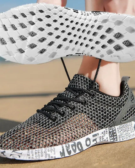 Black and gray sneaker with white sole on a sandy background