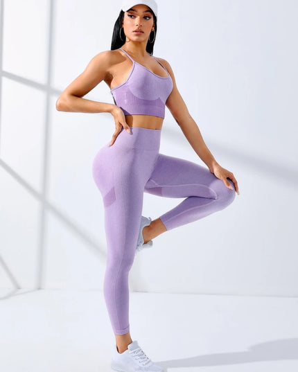 Woman wearing a purple athletic outfit posing against a white background
