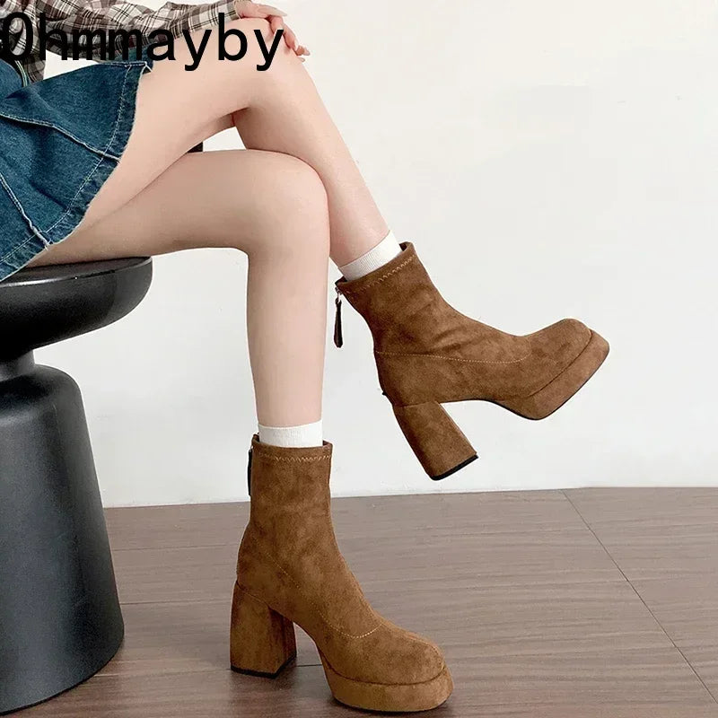 Brown platform boots worn by a person sitting on a chair with a white background.