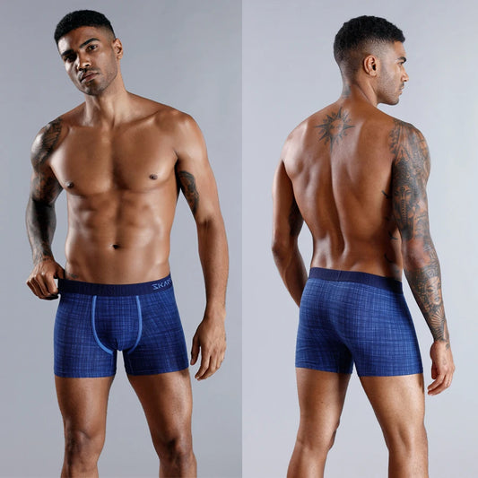 Man wearing blue boxer briefs on a gray background