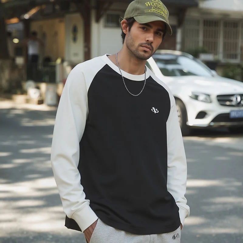 Man wearing a black and white long-sleeve shirt with a cap on a street.