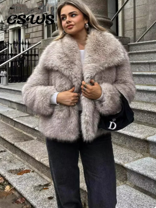 Woman wearing a fur coat standing on stone steps with a building in the background