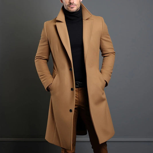 Man wearing a brown coat against a gray background