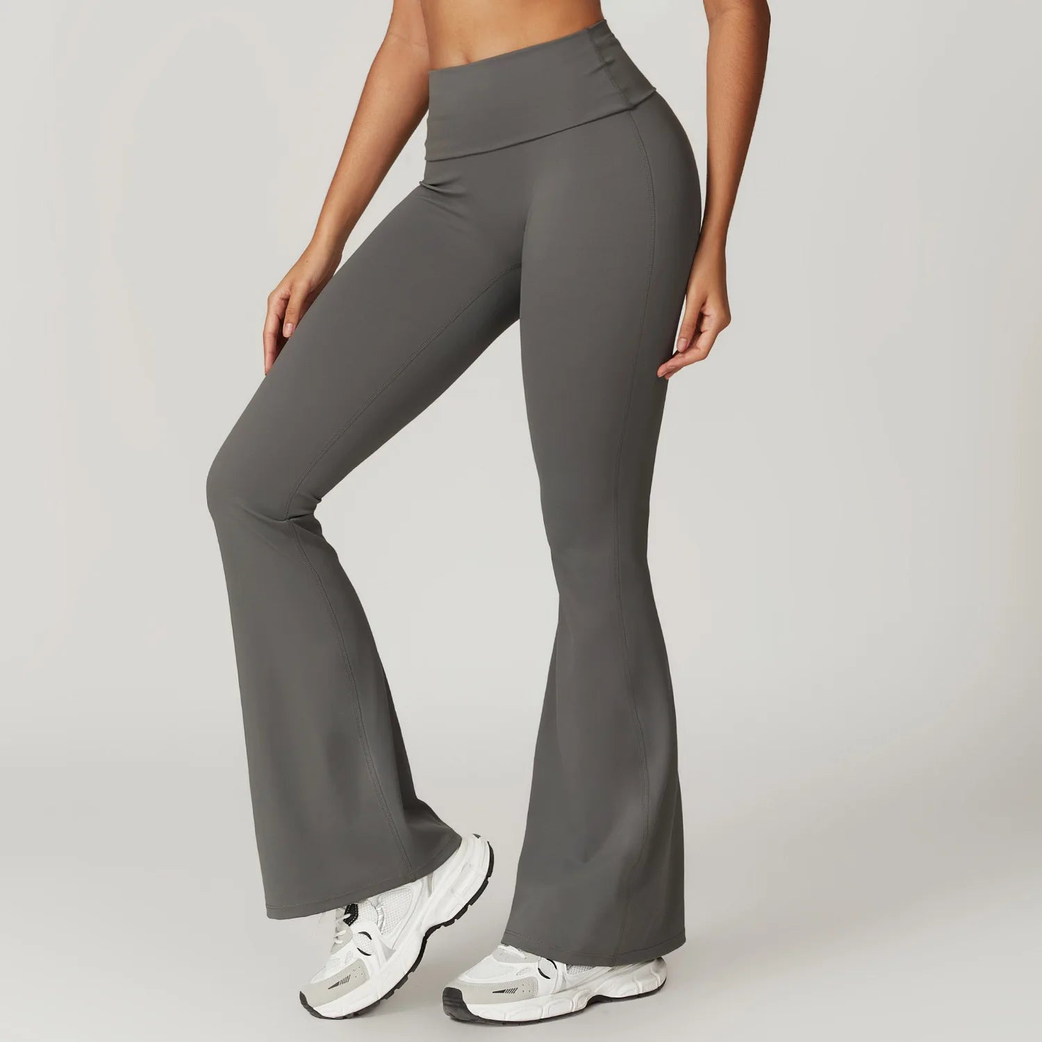 Person wearing gray flared pants on a plain background