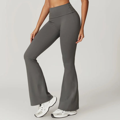 Person wearing gray flared pants on a plain background