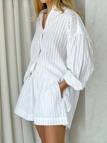 Person wearing a white pleated outfit against a neutral background