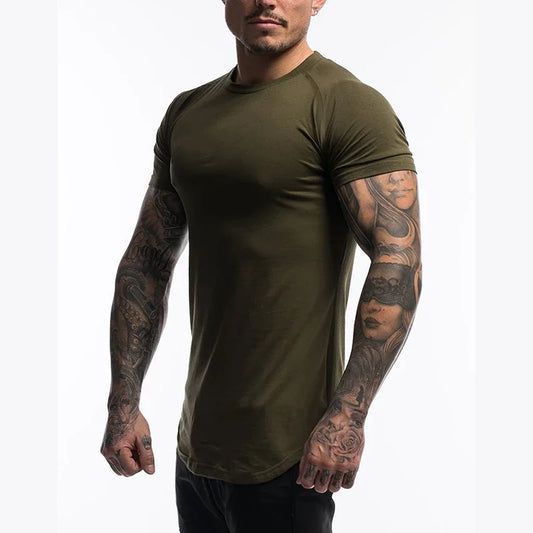 Man wearing an olive green t-shirt with tattoos on arms against a white background