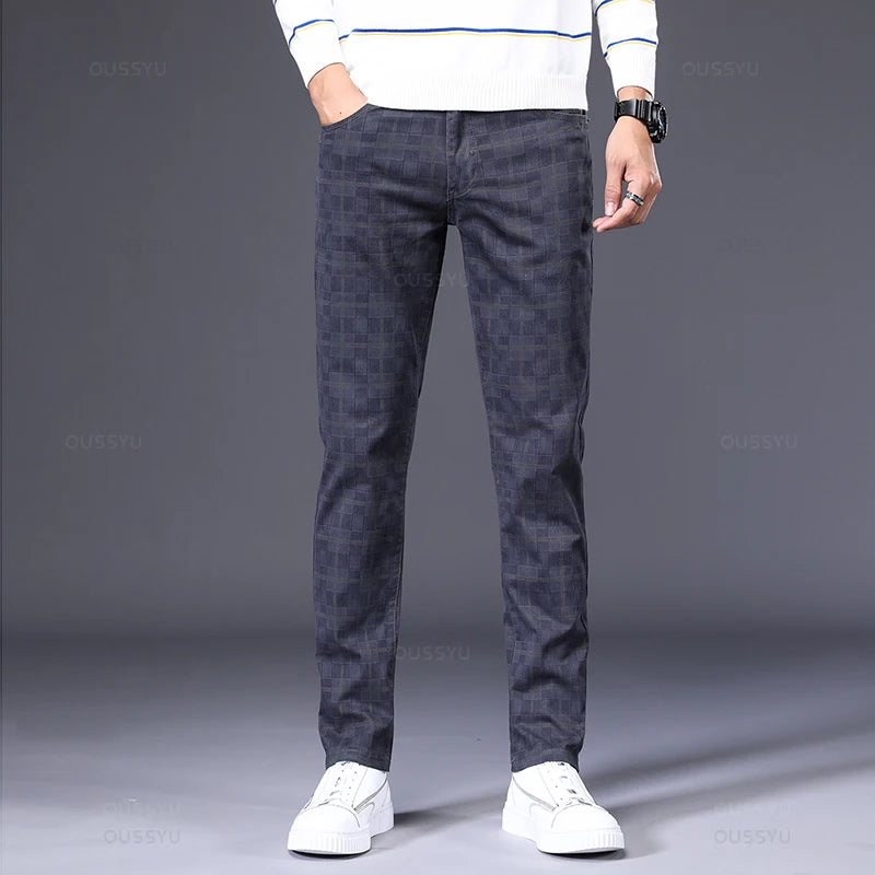 Person wearing dark patterned pants and a white sweater on a gray background