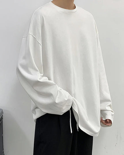 Person wearing a white oversized sweatshirt against a plain background
