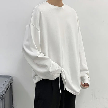 Person wearing a white oversized sweatshirt against a plain background