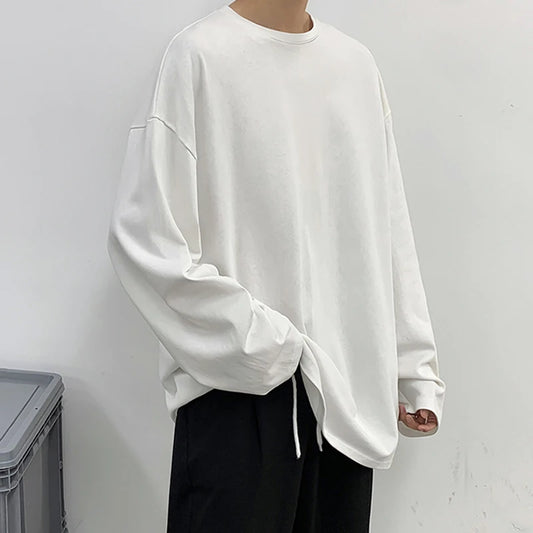 Person wearing a white oversized sweatshirt against a plain background