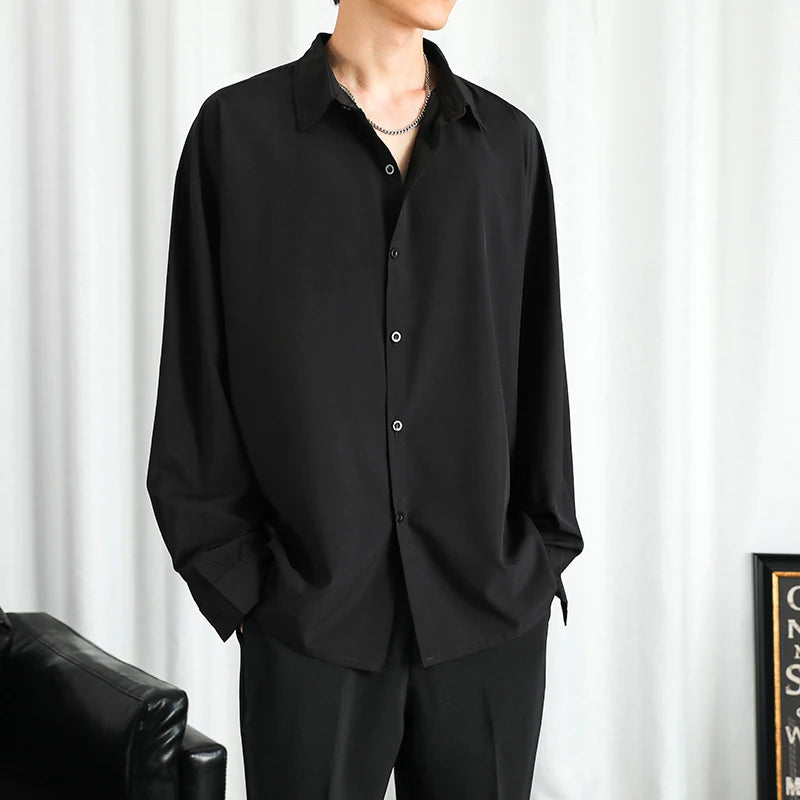 Person wearing a black shirt and pants against a white curtain background