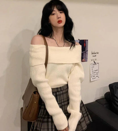 Woman wearing a white off-shoulder sweater and plaid skirt in an indoor setting.