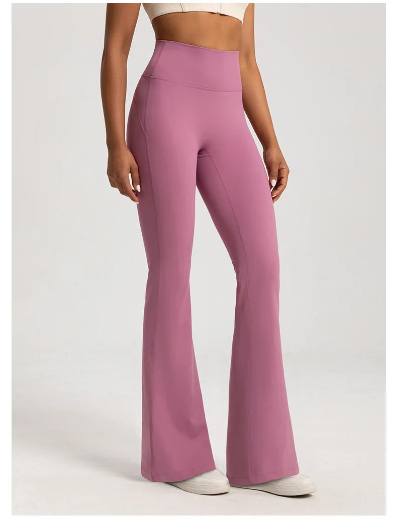 Person wearing pink flared pants on a white background