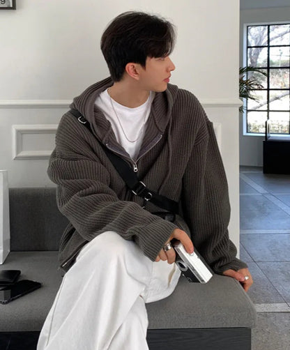 Person sitting on a bench holding a phone, with shopping bags in the background