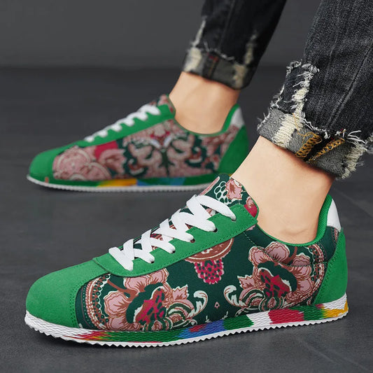 Green floral sneakers worn with ripped jeans on a dark background
