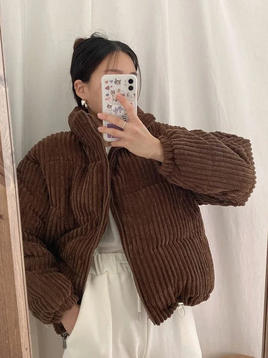 Person wearing a brown corduroy jacket taking a mirror selfie.