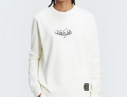 Person wearing a white sweatshirt with branding and white shorts with a green logo on a light gray background