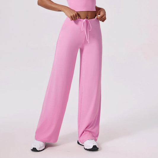 Person wearing a pink outfit with wide-leg pants on a light background