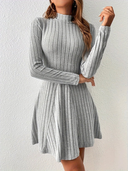 Woman wearing a gray ribbed dress against a white background