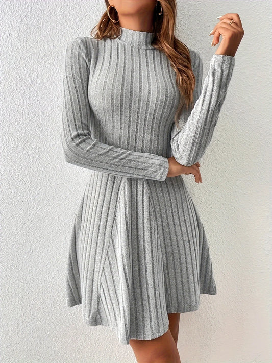 Woman wearing a gray ribbed dress against a white background