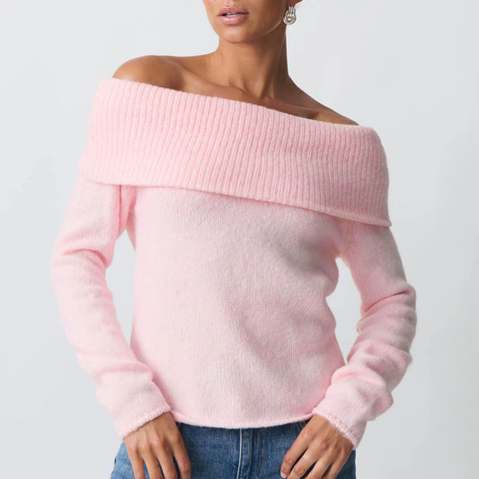 Pink off-shoulder sweater worn by a person on a light gray background