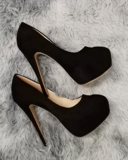 Black high-heeled shoes on a gray textured surface
