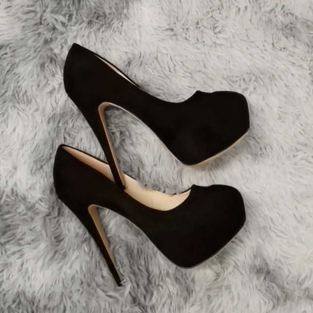 Black high-heeled shoes on a gray textured surface