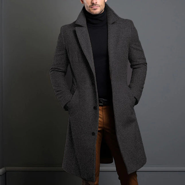 Man wearing a gray overcoat with a plain background