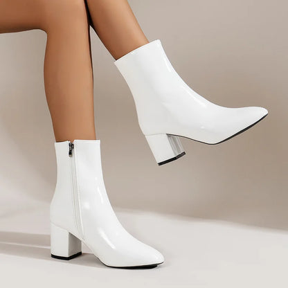 White ankle boots with block heels on a neutral background