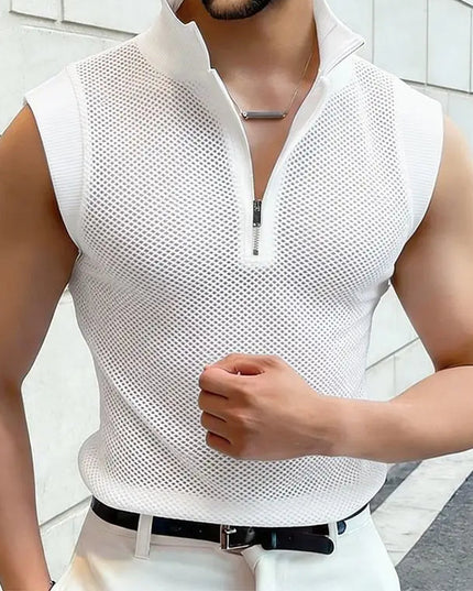 Man wearing a white sleeveless mesh shirt against a light-colored wall.